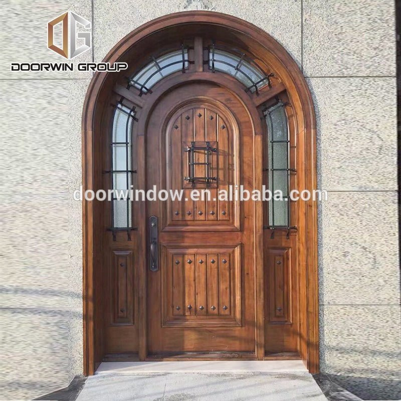Arched top iron clavos door design with Q-Lon weather strip insulation and solid wood front door frame by Doorwin - Doorwin Group Windows & Doors